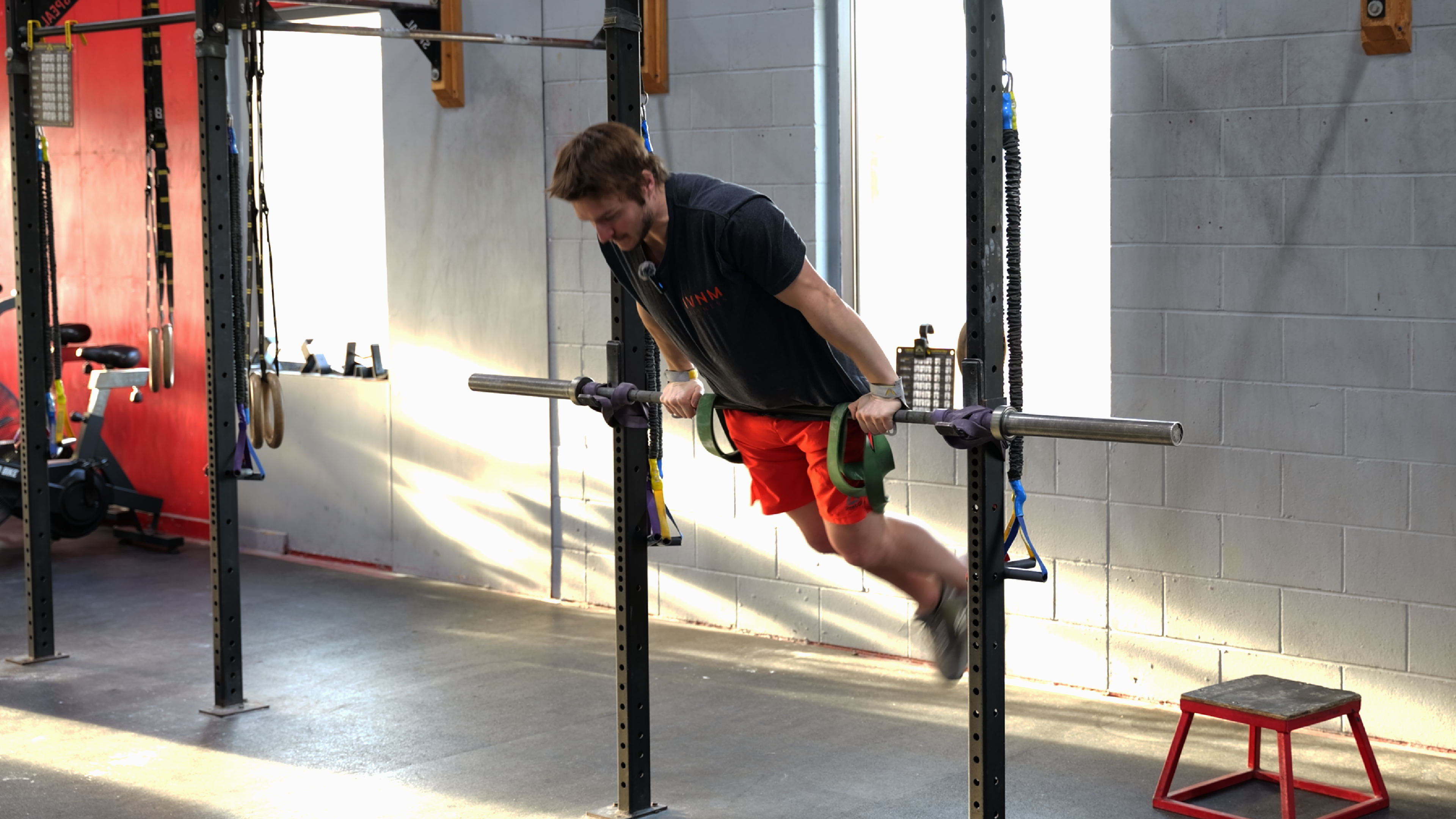 Athlete working on gymnastics progressions — bar muscle ups, toes to bar, ring movements